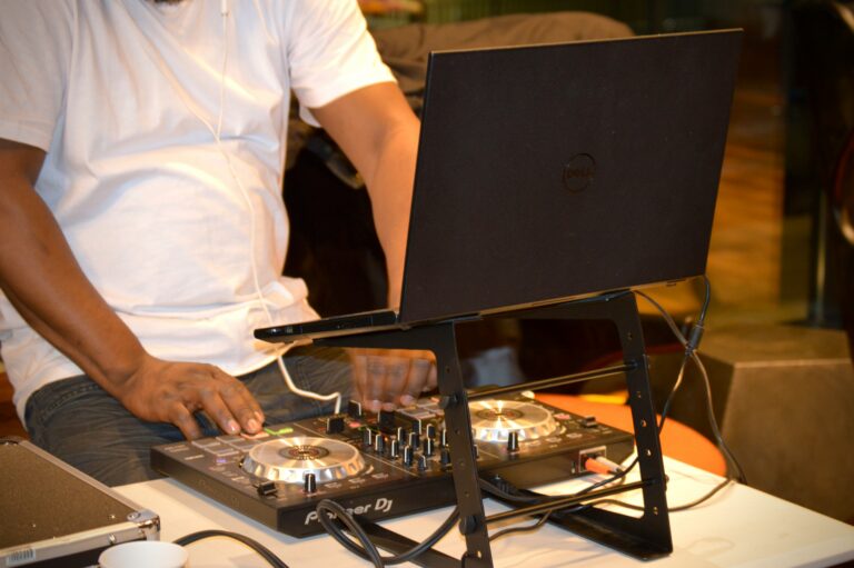 Photo of a DJ mixing music on a Laptop with a Pioneer DJ Controller